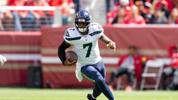 Geno Smith runs with the football.